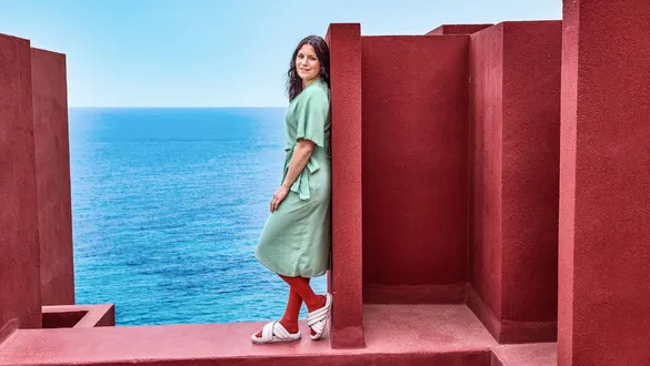 Frau steht lachend am Wasser