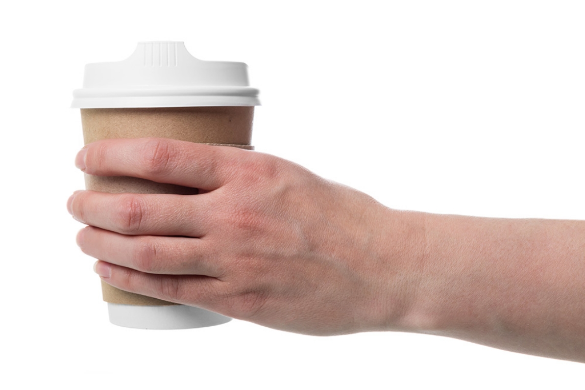 Hand hält einen Kaffeebecher