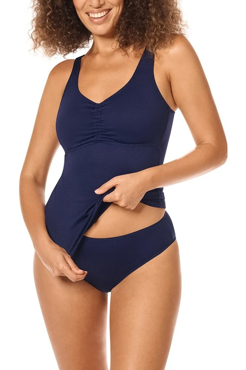 Frau trägt lachend einen Badeanzug Zweiteiler